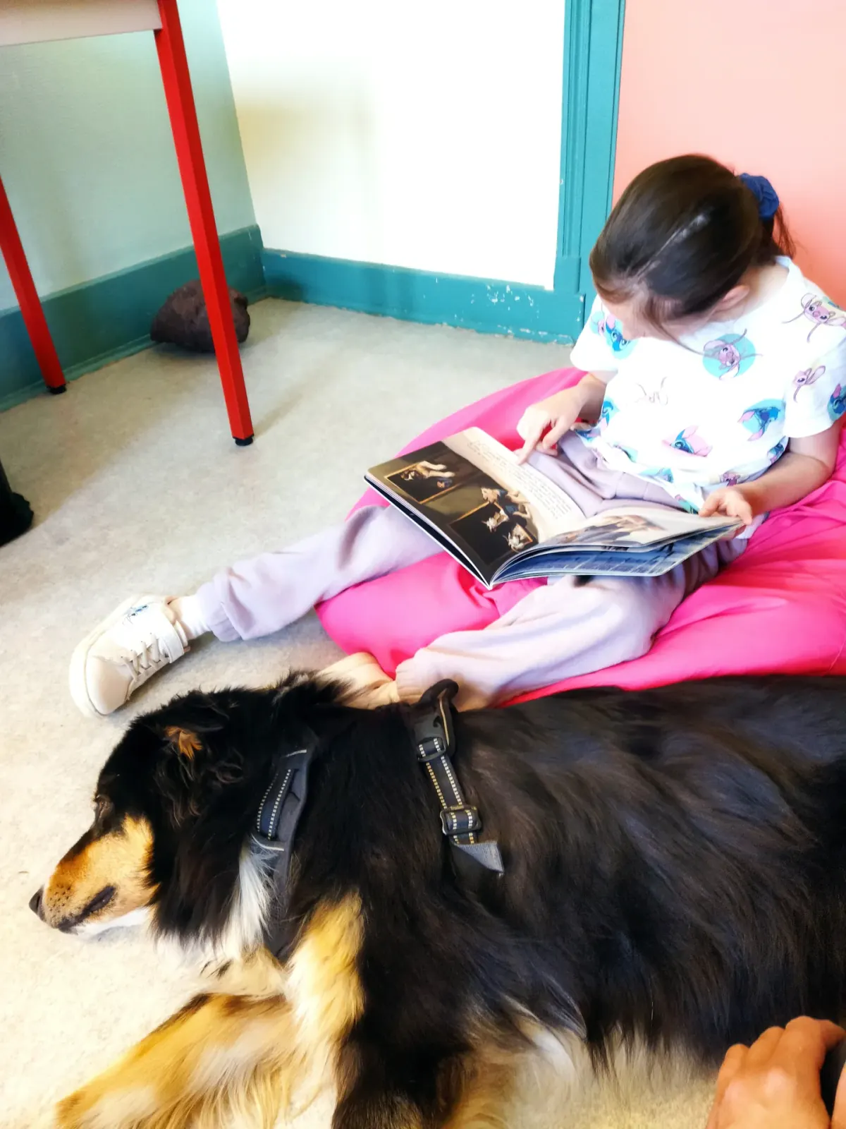 Enfant lisant à voix haute auprès du chien