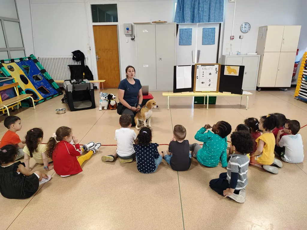 Groupe d'enfants assis en cercle autour d'un chien lors d'un atelier ludo-éducatif
